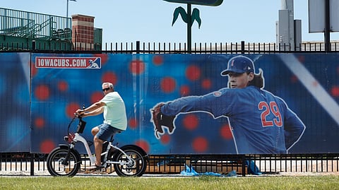 A cyclist rides past Principal Park, home to the Triple-A minor league baseball Iowa Cubs, Thursday, June 25, 2020, in Des Moines, Iowa.