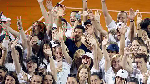 In this photo taken on Sunday, June 14, 2020, Serbia's Novak Djokovic, centre, poses with volunteers and players after the Adria Tour charity tournament in Belgrade, Serbia. Djokovic’s charity tennis exhibition series combined with an overall softening of coronavirus restrictions in Serbia has led to a spike in the number the positive cases among professional athletes.