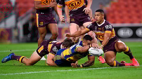 Marata Niukore, center, of the Parramatta Eels reaches out to score a try against the Brisbane Broncos as the National Rugby League resumes play, Thursday, May 28, 2020, in Brisbane, Australia.