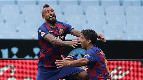Barcelona's Luis Suarez, right, celebrates after with his teammate Barcelona's Arturo Vidal the opening goal during a Spanish La Liga soccer match between RC Celta and Barcelona at the Balaidos stadium in Vigo, Spain, Saturday, June 27, 2020.