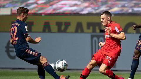 Florian Wirtz of Leverkusen, right, is challenged by FC Bayern Munich's Joshua Kimmich during the German Bundesliga soccer match between Bayer Leverkusen and Bayern Munich in Leverkusen, Germany, Saturday, June 6, 2020.