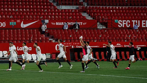 Sevilla players celebrate their Spanish La Liga soccer match victory against Betis in Seville, Spain, Thursday, June 11, 2020.