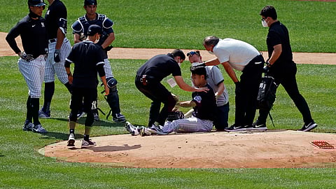 New York Yankees pitcher Masahiro Tanaka is tended to by team medical personnel after being hit by a ball off the bat of Yankees Giancarlo Stanton during a baseball a workout at Yankee Stadium in New York, Saturday, July 4, 2020.