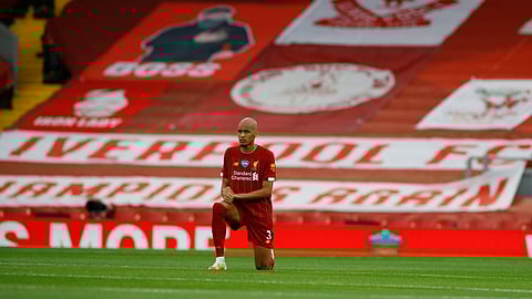 Liverpool's Fabinho takes a knee just prior to the start of the English Premier League soccer match between Liverpool and Chelsea at Anfield Stadium in Liverpool, England, Wednesday, July 22, 2020.