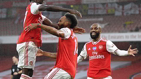 Arsenal's Pierre-Emerick Aubameyang, centre, is congratulated by teammates after scoring his team's first goal during the English Premier League soccer match between Arsenal and Leicester at Emirates Stadium in London, England, Tuesday, July 7, 2020.
