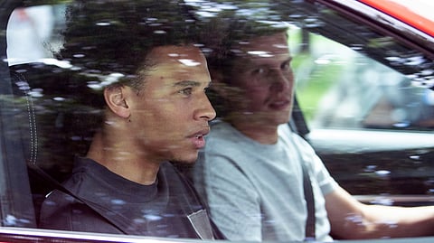 FC Bayern soccer club newcomer Leroy Sane, left, sits in a car as he leaves the FC Bayern training ground in Munich, Germany, July 2, 2020. FC Bayern newcomer Sane arrived in Munich the day before.