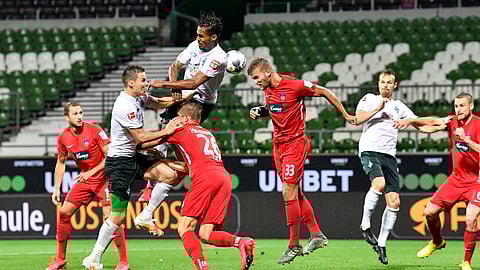 Bremen's Theodor Gebre Selassie, up, and Heidenheim's Timo Beermann, center, challenge for the ball during the German Bundesliga relegation first leg soccer match between Werder Bremen and 1. FC Heidenheim in Bremen, Germany, Thursday, July 2, 2020. Because of the coronavirus outbreak all soccer matches of the German Bundesliga take place without spectators.