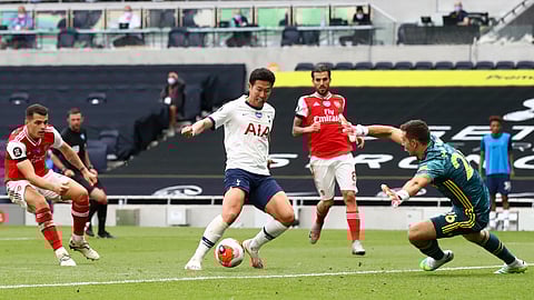Tottenham's Son Heung-min, center, attempts and fails to score past Arsenal's goalkeeper Emiliano Martinez, right, during the English Premier League soccer match between Tottenham Hotspur and Arsenal at the Tottenham Hotspur Stadium in London, England, Sunday, July 12, 2020.