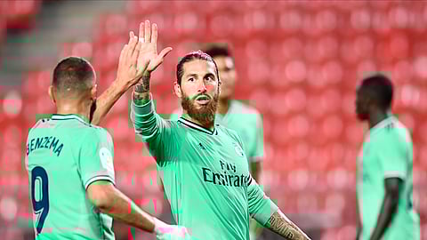 Real Madrid's Sergio Ramos, center, gestures with his teammate Benzema during the Spanish La Liga soccer match between Granada and Real Madrid at the Los Carmenes stadium in Granada, Spain, Monday, July 13, 2020.