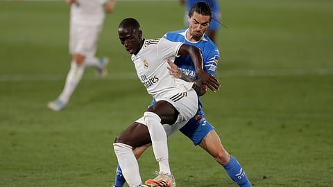 Real Madrid's Ferland Mendy, left, fights for the ball with Getafe's Jason during the Spanish La Liga soccer match between Real Madrid and Getafe at the Alfredo di Stefano stadium in Madrid, Spain, Thursday, July 2, 2020.