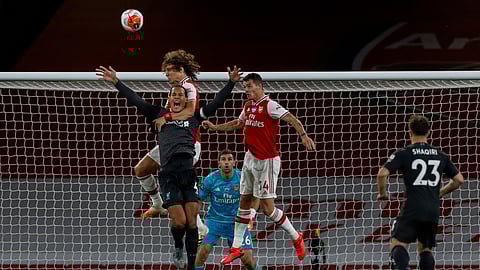 Arsenal's David Luiz grabs Liverpool's Virgil van Dijk, foreground and left, during the English Premier League soccer match between Arsenal and Liverpool at the Emirates Stadium in London, England, Wednesday, July 15, 2020.