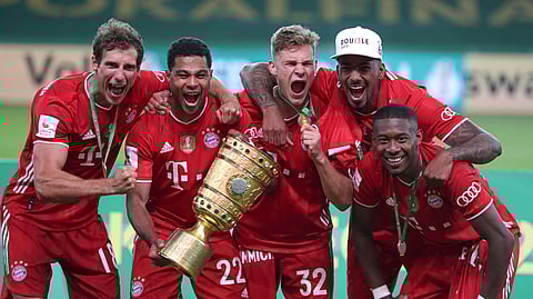 Bayern Munich players celebrate with the trophy after winning the German soccer cup (DFB Pokal) final match between Bayer 04 Leverkusen and FC Bayern Munich in Berlin, Germany, Saturday, July 4, 2020.