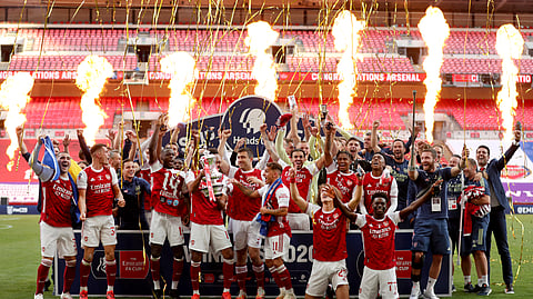Pyrotechnics go off as Arsenal's players celebrate with the trophy after the FA Cup final soccer match between Arsenal and Chelsea at Wembley stadium in London, England, Saturday, Aug.1, 2020.