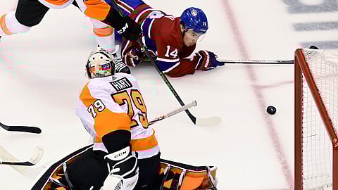 Montreal Canadiens center Nick Suzuki (14) fails to connect with the puck as Philadelphia Flyers goaltender Carter Hart (79) defends the net during the second period of Game 3 of an NHL hockey playoff first-round series Sunday, Aug. 16, 2020, in Toronto.
