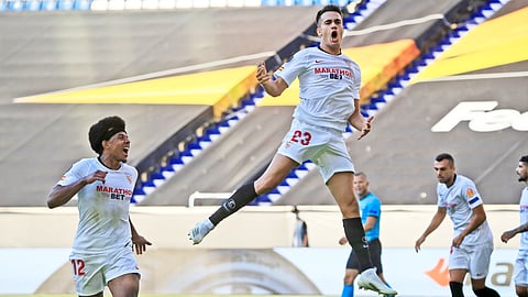 Sevilla's Sergio Reguilon, right, celebrates after scoring his side's first goal during the Europa League, round of 16 soccer match between Roma and Sevilla, at the Schauinsland-Reisen-Arena in Duisburg, Germany, Thursday, Aug. 6, 2020.