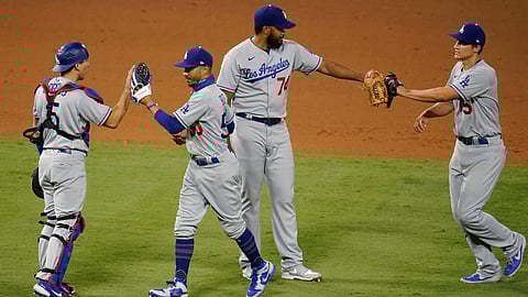 Los Angeles Dodgers' Chris Taylor, left, scores past Los Angeles Angels catcher Max Stassi on a sacrifice fly hit by Max Muncy during the 10th inning of a baseball game Saturday, Aug. 15, 2020, in Anaheim, Calif. The Dodgers won 6-5.