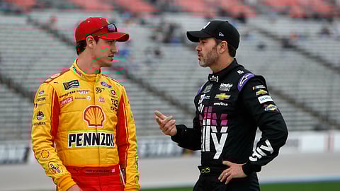 FILE - In this March 29, 2019, file photo, Jimmie Johnson, right, chats with Joey Logano before qualifying for the NASCAR Cup Series auto race at Texas Motor Speedway in Fort Worth, Texas. The final three playoff spots are up for grabs as stock-car racing returns to the high-banked superspeedway in Daytona Beach, Fla., two weeks after running the road course. Nearly half the field is looking to clinch a postseason berth with a victory, including seven-time series champion Jimmie Johnson.