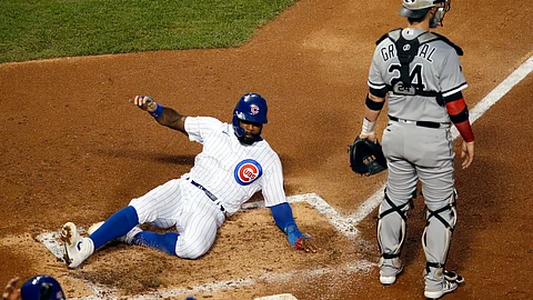 Chicago Cubs' Jason Heyward, left, slides into home plate past Chicago White Sox catcher Yasmani Grandal (24) on a two-RBI double off the bat of teammate Victor Caratini during the second inning of a baseball game Saturday, Aug. 22, 2020, in Chicago.