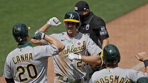 Oakland Athletics' Stephen Piscotty, center, celebrates with Mark Canha (20) and Robbie Grossman (8) after hitting a three-run home run off San Francisco Giants' Dereck Rodriguez in the fifth inning of a baseball game Sunday, Aug. 16, 2020, in San Francisco.