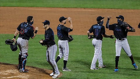 Miami Marlins' Francisco Cervelli (29) Nick Vincent (44) and Logan Forsythe (11) celebrate with teammates after a baseball game against the New York Mets Friday, Aug. 7, 2020, in New York. The Marlins won 4-3.