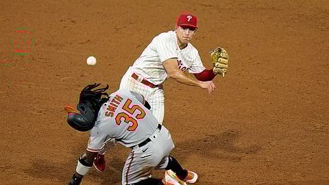 Philadelphia Phillies' second baseman Scott Kingery, top, throws to first after forcing out Baltimore Orioles' Dwight Smith Jr. at second on a fielder's choice by Austin Hays during the sixth inning of a baseball game, Tuesday, Aug. 11, 2020, in Philadelphia. Hays was safe at first on the play.