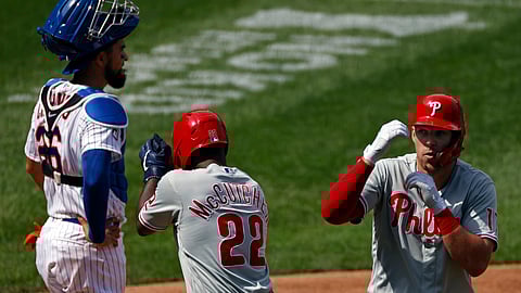 Rhys Hoskins celebrates a two-run home run with Andrew McCutchen (22) in front of Mets catcher Robinson Chirinos Monday