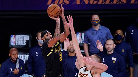 Los Angeles Lakers' Anthony Davis (3) shoots a 3-point basket over Denver Nuggets' Nikola Jokic (15) at the end of an NBA conference final playoff basketball game Sunday, Sept. 20, 2020, in Lake Buena Vista, Fla. The Lakers won 105-103.