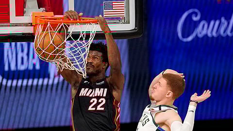 Miami Heat's Jimmy Butler (22) dunks the ball after getting past Milwaukee Bucks' Donte DiVincenzo (0) during the second half of an NBA basketball conference semifinal playoff game, Monday, Aug. 31, 2020, in Lake Buena Vista, Fla.
