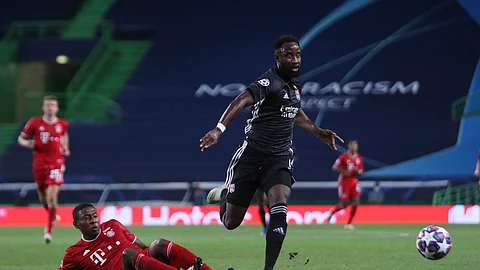 Lyon's Moussa Dembele, right, goes for the ball as Bayern's Lucas Hernandez falls down during the Champions League semifinal soccer match between Lyon and Bayern Munich at the Jose Alvalade stadium in Lisbon, Portugal, Wednesday, Aug. 19, 2020.