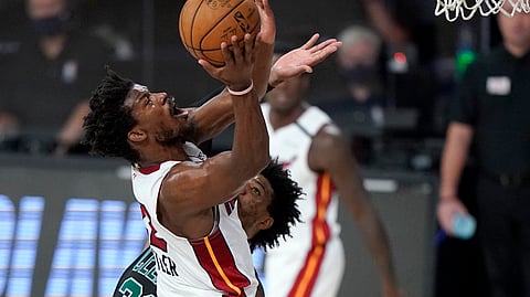 Miami Heat's Jimmy Butler, front, goes up for a shot over Boston Celtics' Marcus Smart, rear, during the first half of an NBA conference final playoff basketball game, Tuesday, Sept. 15, 2020, in Lake Buena Vista, Fla.