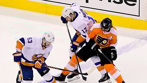 Philadelphia Flyers center Sean Couturier (14) tries to hold onto the puck under pressure from New York Islanders center Casey Cizikas (53) and teammate Matt Martin (17) during the second period of an NHL Stanley Cup Eastern Conference playoff hockey game in Toronto, Ontario, Tuesday, Sept. 1, 2020.