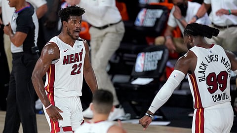 Miami Heat's Jimmy Butler (22), Tyler Herro, bottom center, and Jae Crowder (99) celebrate a game tying basket by Butler late in the second half of an NBA conference final playoff basketball game against the Boston Celtics on Tuesday, Sept. 15, 2020, in Lake Buena Vista, Fla.
