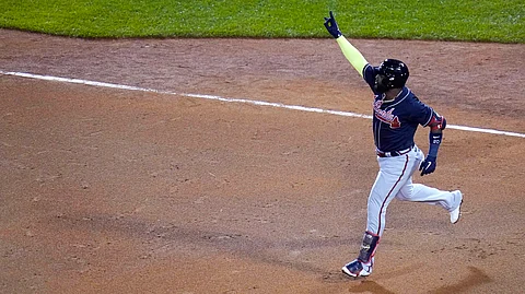 Atlanta Braves designated hitter Marcell Ozuna raises his arm as he rounds the bases on his solo home run in the seventh inning of a baseball game against the Boston Red Sox, Wednesday Sept. 2, 2020, in Boston.