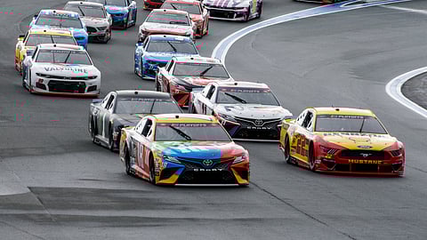 Kyle Busch (18) and Joey Logano (22) lead the pack out of Turn 2 in a NASCAR Cup Series auto race at Charlotte Motor Speedway in Concord, N.C., Sunday, Oct. 11, 2020.