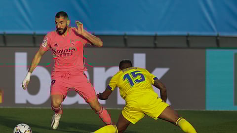 Real Madrid's Karim Benzema in action by Cadiz's Carlos Akapo during the Spanish La Liga soccer match between Real Madrid and Cadiz at the Alfredo di Stefano stadium in Madrid, Spain, Saturday, Oct. 17, 2020.