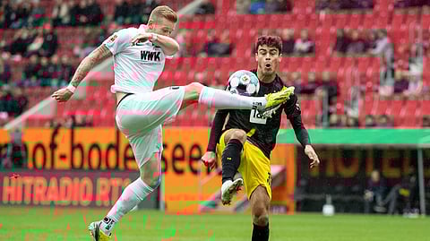 Andre Hahn from Augsburg, left, and Giovanni Reyna from Dortmund challenge for the ball during the German Bundesliga soccer match between FC Augsburg and Borussia Dortmund in Augsburg, Germany, Saturday, Sept. 26, 2020.
