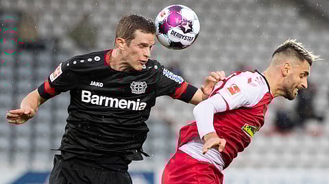 Leverkusen's Sven Bender, left, in action against Freiburg's Vincenzo Grifo during their Bundesliga soccer match at the Black Forest Stadium in Freiburg im Breisgau, Germany, Sunday Nov. 1, 2020.