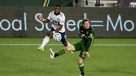 Vancouver Whitecaps forward Cristian Dajome, left, puts a shot on goal as Portland Timbers defender Jorge Villafana defends during the first half of an MLS soccer match in Portland, Ore., Sunday, Nov. 1, 2020.