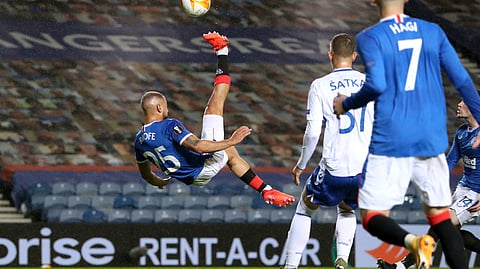 Rangers' Kemar Roofe, left, in an unsuccessful attempt at an overhead kick on goal against Lech Poznan, during their Europa League soccer match at Ibrox Stadium in Glasgow, Scotland, Thursday Oct. 29, 2020.
