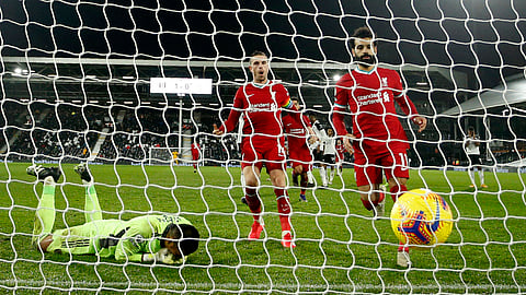 Liverpool's Mohamed Salah, right, runs to retrieve the ball after scoring from the penalty spot during the English Premier League soccer match between Fulham and Liverpool, at Craven Cottage stadium, London, Sunday, Dec. 13, 2020.