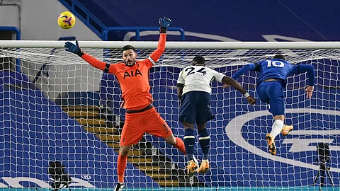 Tottenham's goalkeeper Hugo Lloris jumps for the ball with Tottenham's Serge Aurier, center, and Chelsea's Christian Pulisic, right, during the English Premier League soccer match between Chelsea and Tottenham Hotspur at Stamford Bridge in London, England, Sunday, Nov. 29, 2020.