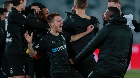 Moenchengladbach's players celebrate at the end of the Champions League group B soccer match between Real Madrid and Borussia Monchengladbach at the Alfredo Di Stefano stadium in Madrid, Spain, Wednesday, Dec. 9, 2020.