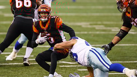 Cincinnati Bengals quarterback Ryan Finley (5) is sacked by Dallas Cowboys defensive tackle Tyrone Crawford (98) in the second half of an NFL football game in Cincinnati, Sunday, Dec. 13, 2020.
