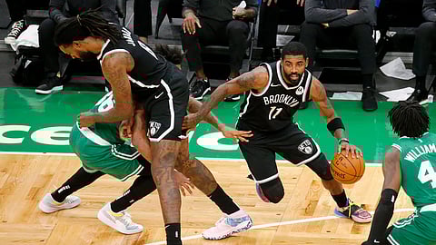 Brooklyn Nets guard Kyrie Irving (11) drives past Boston Celtics guard Marcus Smart as teammate DeAndre Jordan sets a pick during the first half of an NBA preseason basketball game, Friday, Dec. 18, 2020, in Boston.