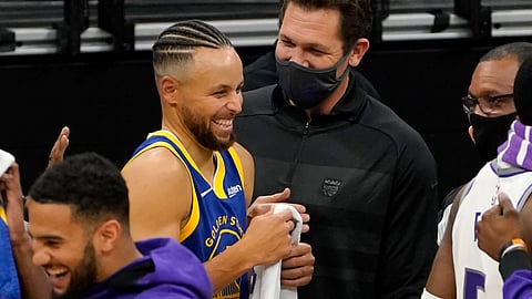 Golden State Warriors guard Stephen Curry, center left, laughs during a conversation with Sacramento Kings head coach Luke Walton after the Warriors beat the Kings 113-109 in an NBA preseason basketball game in Sacramento, Calif., Thursday, Dec. 17, 2020.