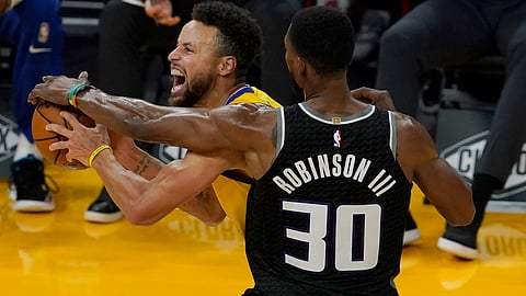 Golden State Warriors guard Stephen Curry, left, is defended by Sacramento Kings forward Glenn Robinson III during the first half of an NBA basketball game in San Francisco, Monday, Jan. 4, 2021.