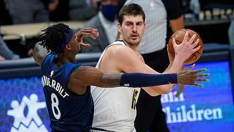 Denver Nuggets center Nikola Jokic, right, looks to pass the ball vs. Minnesota Timberwolves forward Jarred Vanderbilt.