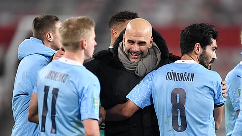 Manchester City's head coach Pep Guardiola, right, congratulates his players after the English League Cup semifinal soccer match between Manchester United and Manchester City at Old Trafford in Manchester, England, Wednesday, Jan. 6, 2021.