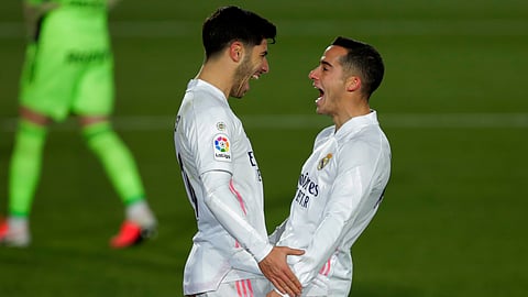 Real Madrid's Marco Asensio, left, celebrates with teammate Lucas Vazquez after scoring his side's second goal during the Spanish La Liga soccer match between Real Madrid and Celta Vigo at the Alfredo Di Stefano stadium in Madrid, Spain, Saturday, Jan. 2, 2021.