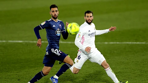 Celta Vigo's Brais Mendez, left, runs for the ball with Real Madrid's Nacho during the Spanish La Liga soccer match between Real Madrid and Celta Vigo at the Alfredo Di Stefano stadium in Madrid, Spain, Saturday, Jan. 2, 2021.